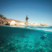 SUP w ciepłych wodach niebieskich z klifu i nadmorskiej promenadzie